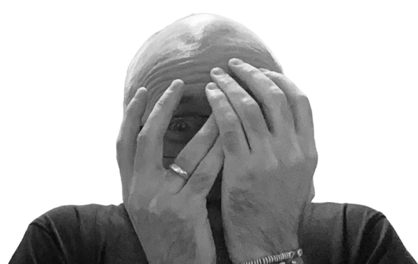 Andre verdeckt sein Gesicht und schämt sich, weil er prokrastiniert und nichts schafft.