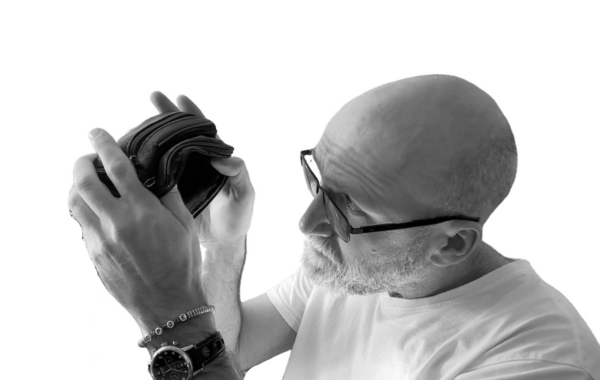 Andre schaut in sein leeres Portmonee, um zu zeigen, wie arm er ist.