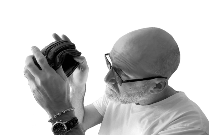 Andre schaut in sein leeres Portmonee, um zu zeigen, wie arm er ist.